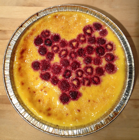 Bird's eye view of the cooked custard. The raspberries form the shape of a heart.