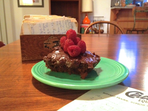 Brownies on a plate topped with raspberries